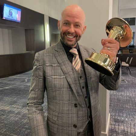 Charlie Austin Cryer's father Jon Cryer photographed with an award in his hand. 